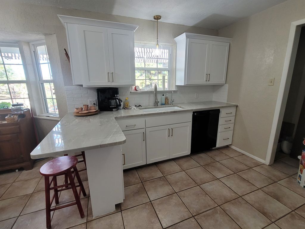 Refaced white Shaker kitchen with a peninsula and brushed nickel pulls